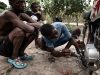 Pelikito 17 anni, ripara la sua motocicletta mentre Tiupi e Alfredo lo guardano lavorare. Batey Lichi Lichima, provincia de La Romana -  Repubblica Dominicana